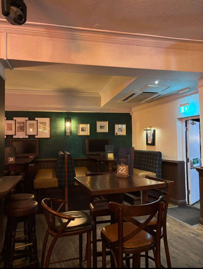 A dining corner at O'Farrell's with tables laid ready beneath framed pictures